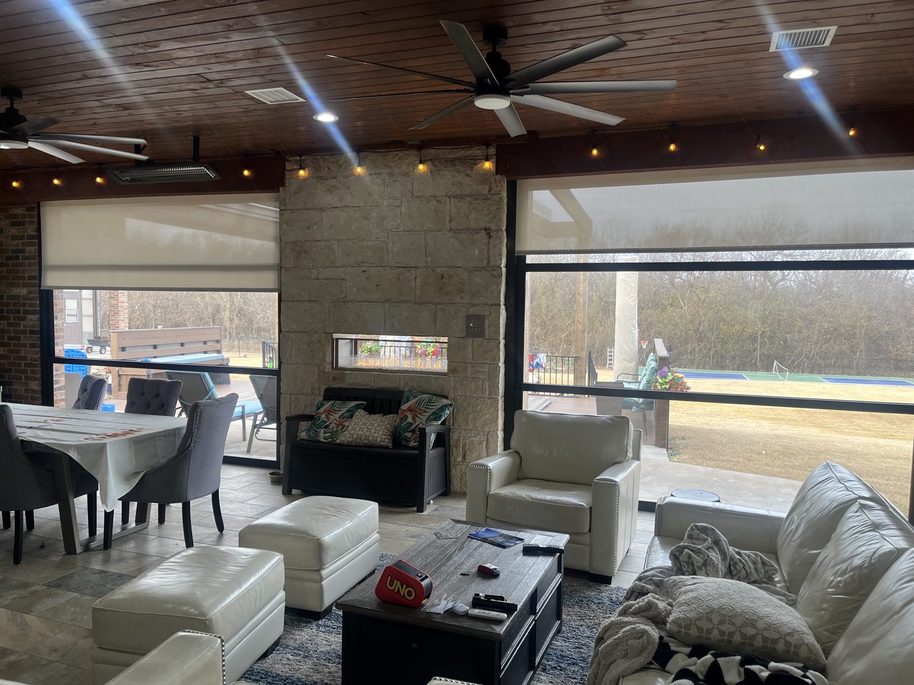 Stax interior motorized shades enclosing a covered patio living room
