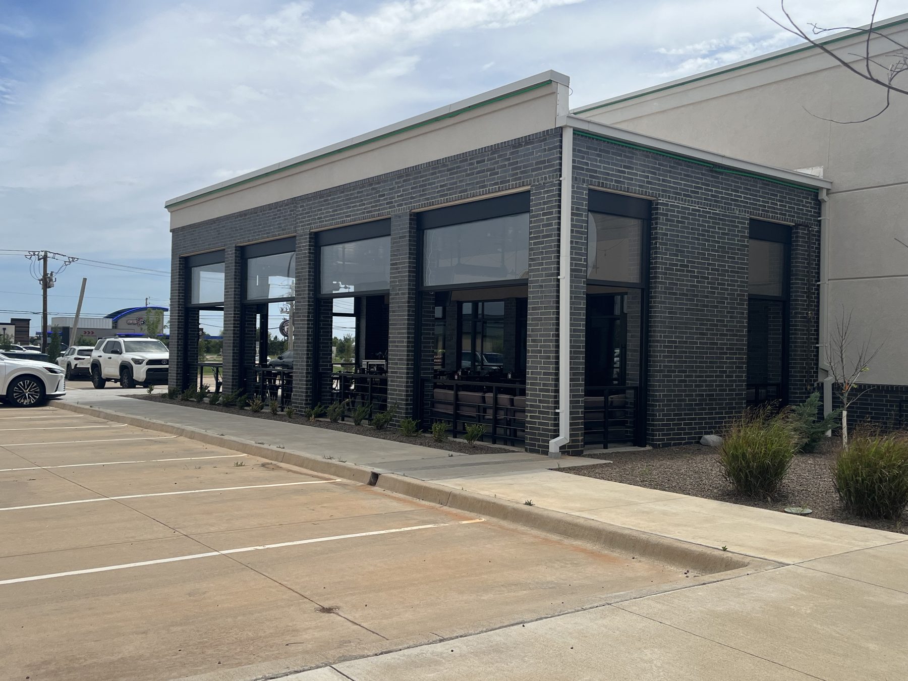 Exterior of a commercial patio with motorized Stax screens along the storefront