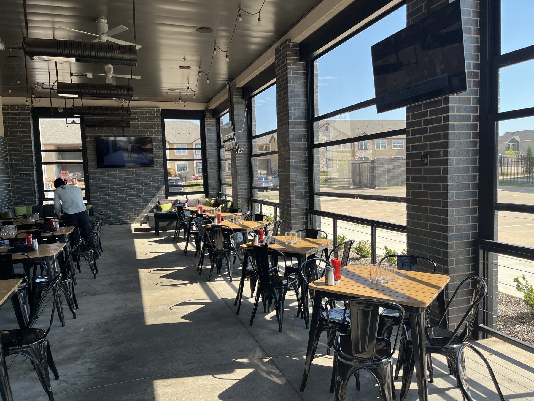 Covered restaurant patio dining area enclosed with Stax motorized screens